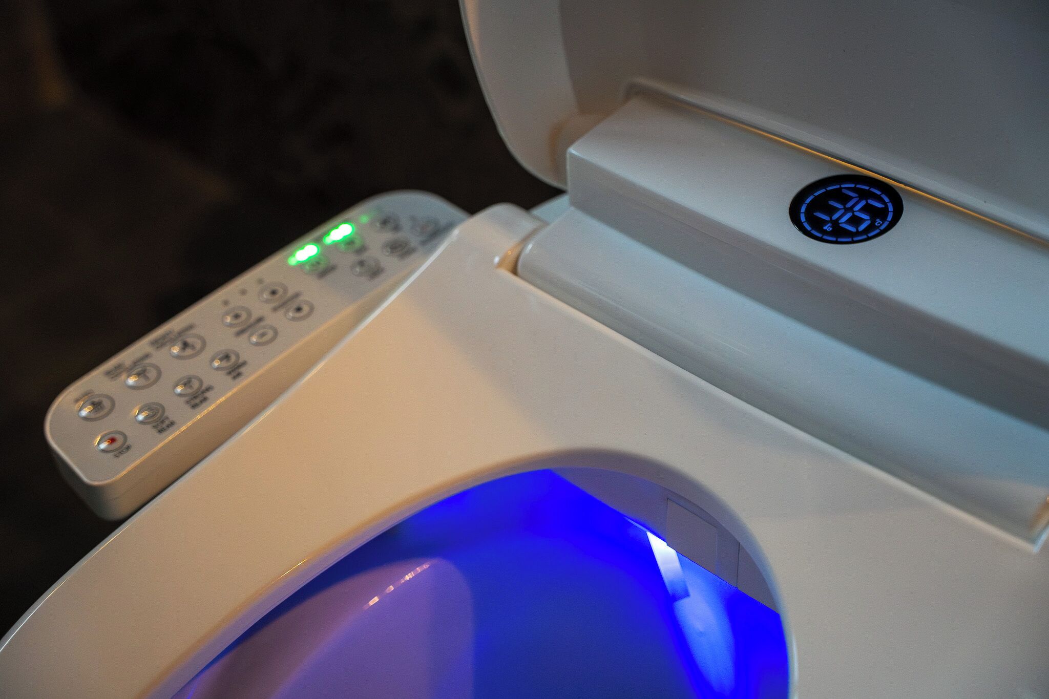 A toilet with a control panel and a digital display.