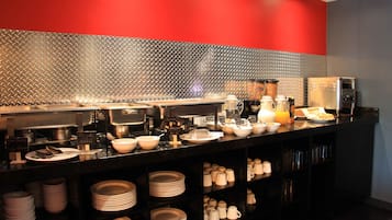A buffet setup with various dishes and utensils.