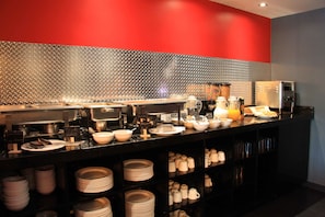 A buffet setup with various dishes and utensils.
