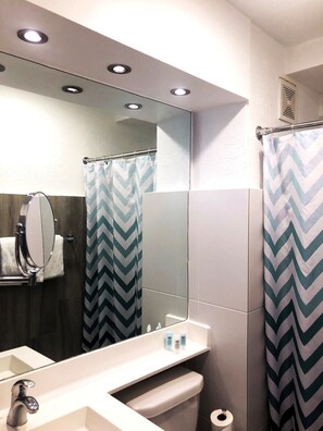 A modern bathroom with a mirror, sink, and toilet. - The Wave Hotel Condado (San Juan)