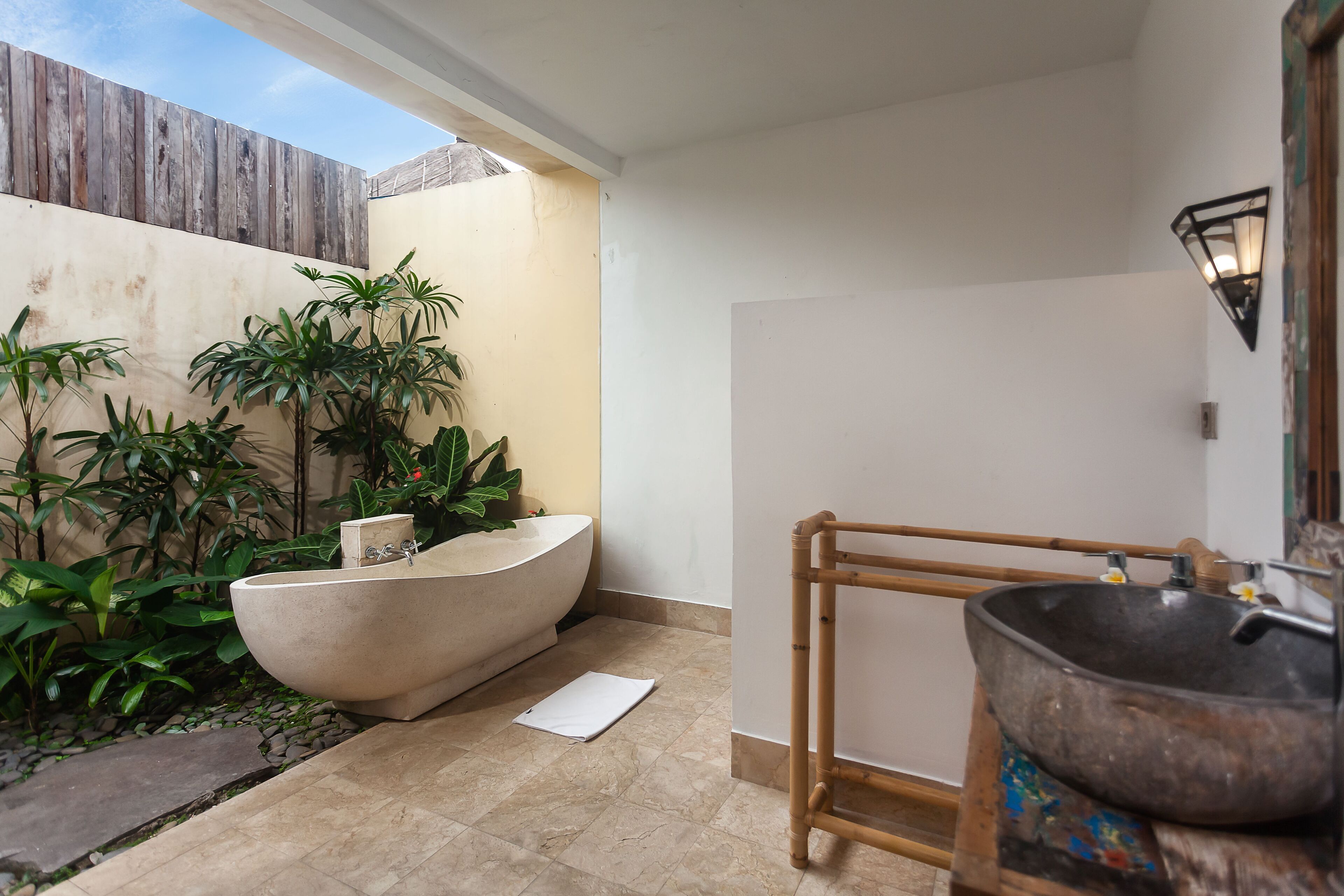 Ein Badezimmer mit freistehender Badewanne, einer Holzbadewanne und einem Waschbecken mit Vessel-Becken.
