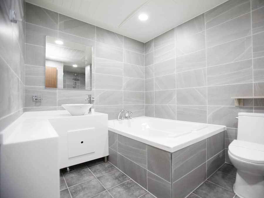Een moderne badkamer met een bad, toilet en wastafel.