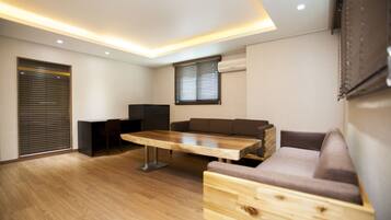 Una sala de estar moderna con una mesa de centro de madera, un sofá y un televisor montado en la pared.