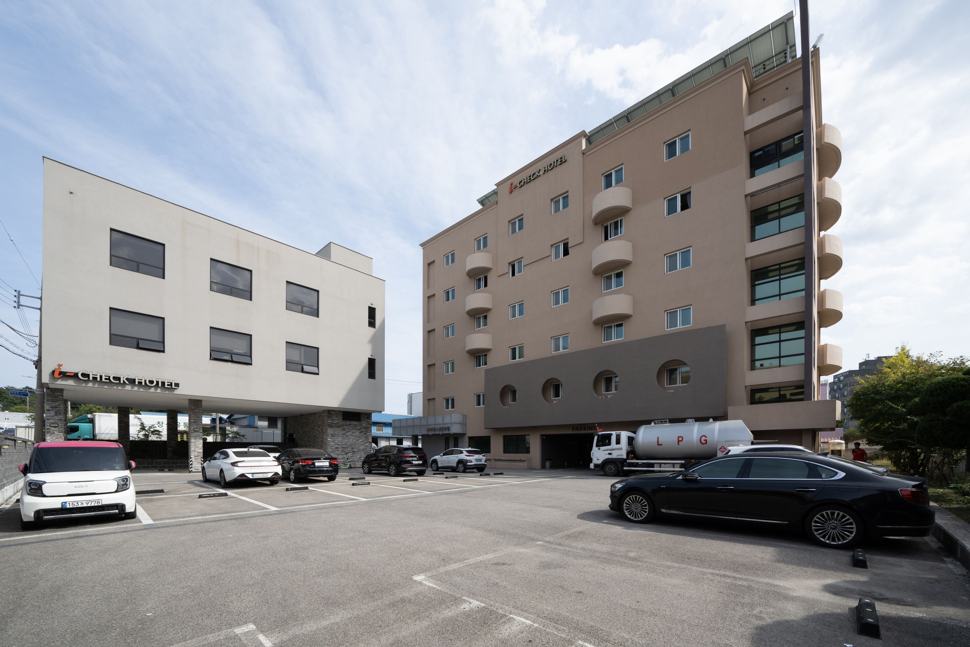 A Check Hotel with a parking lot and a LPG fuel station.
