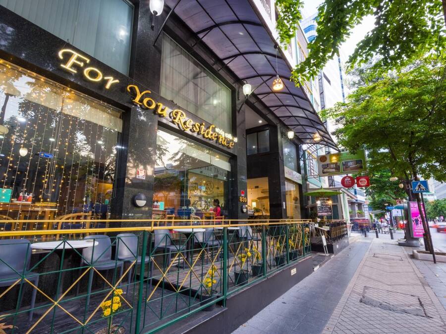 Un restaurant doté d’une terrasse, d’une façade en verre et d’une enseigne indiquant « For You Residence ».