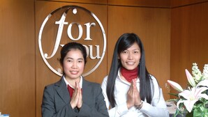 Two individuals at a reception desk with a 'for you' sign in the background. - For You Residence (Bangkok)
