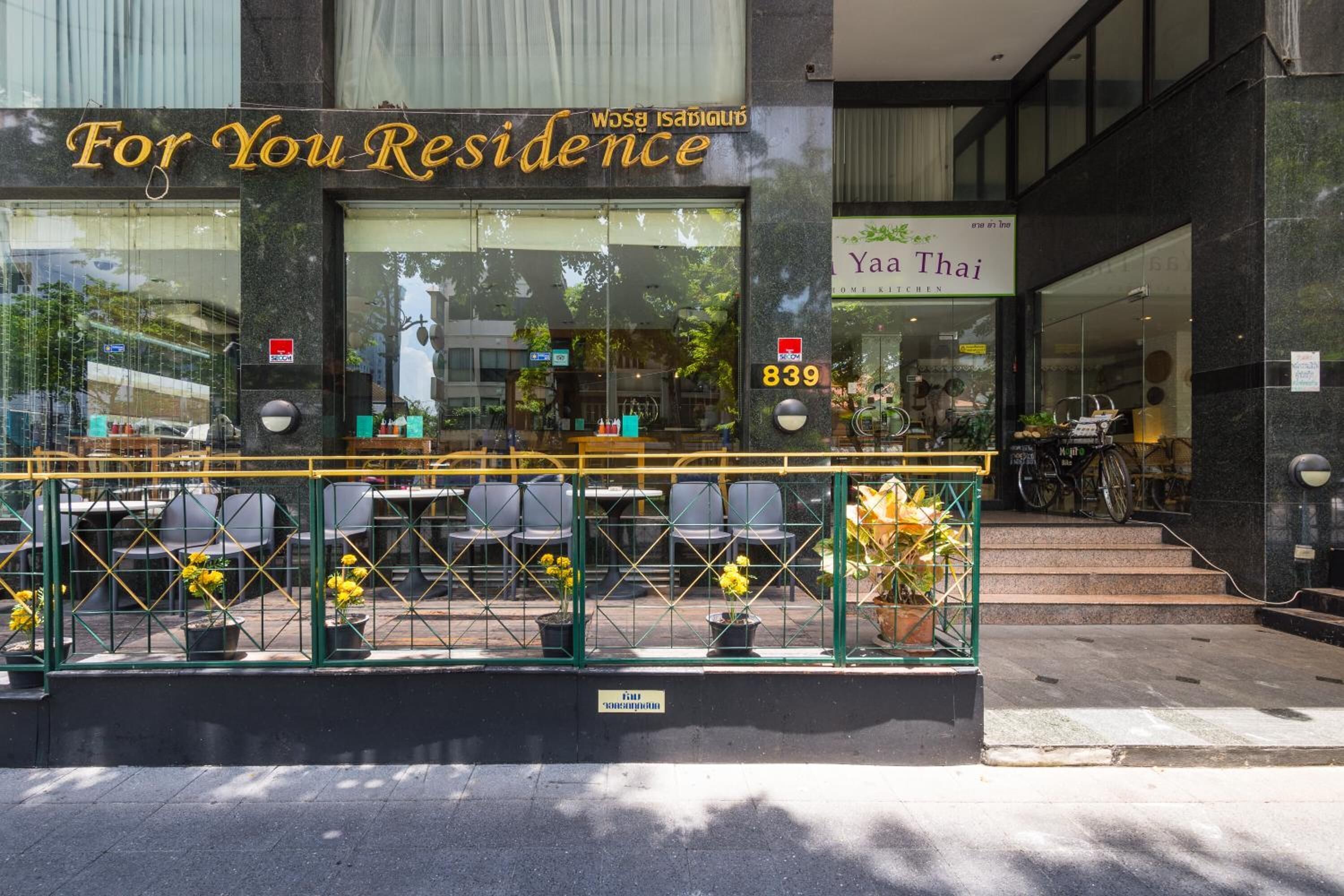 Un restaurante llamado 'For You Residence' con terraza y una bicicleta estacionada afuera.