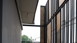 A balcony with a concrete floor, a wooden bench, and a large decorative pot. - 9 Hostel - Hostel (Chiang Mai)