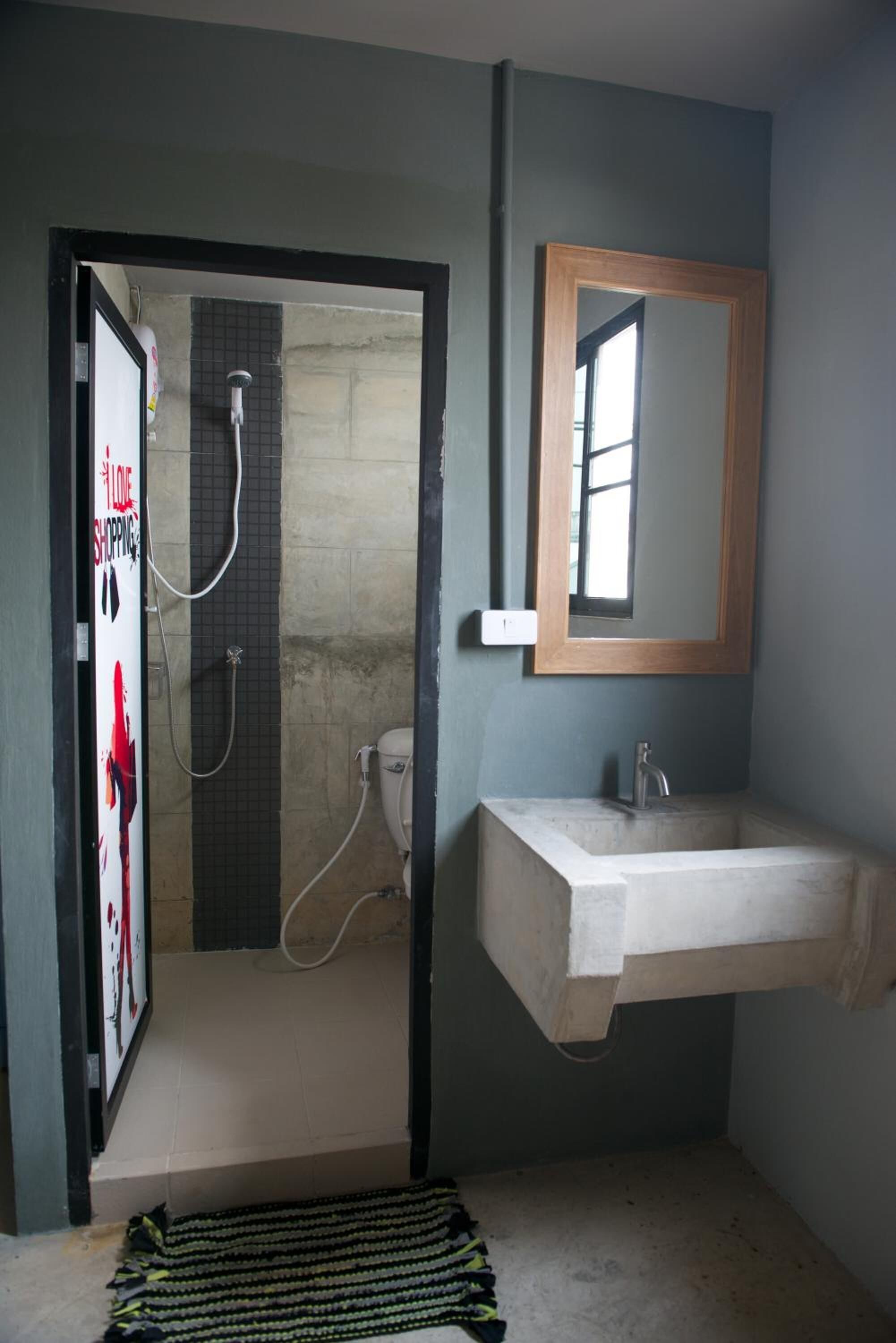 A bathroom with a shower, a sink, and a mirror.