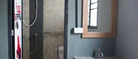 A bathroom with a shower, a sink, and a mirror.