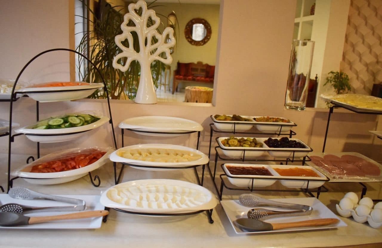 A buffet setup with various food items and utensils.