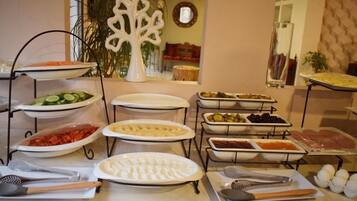 A buffet setup with various food items and utensils.