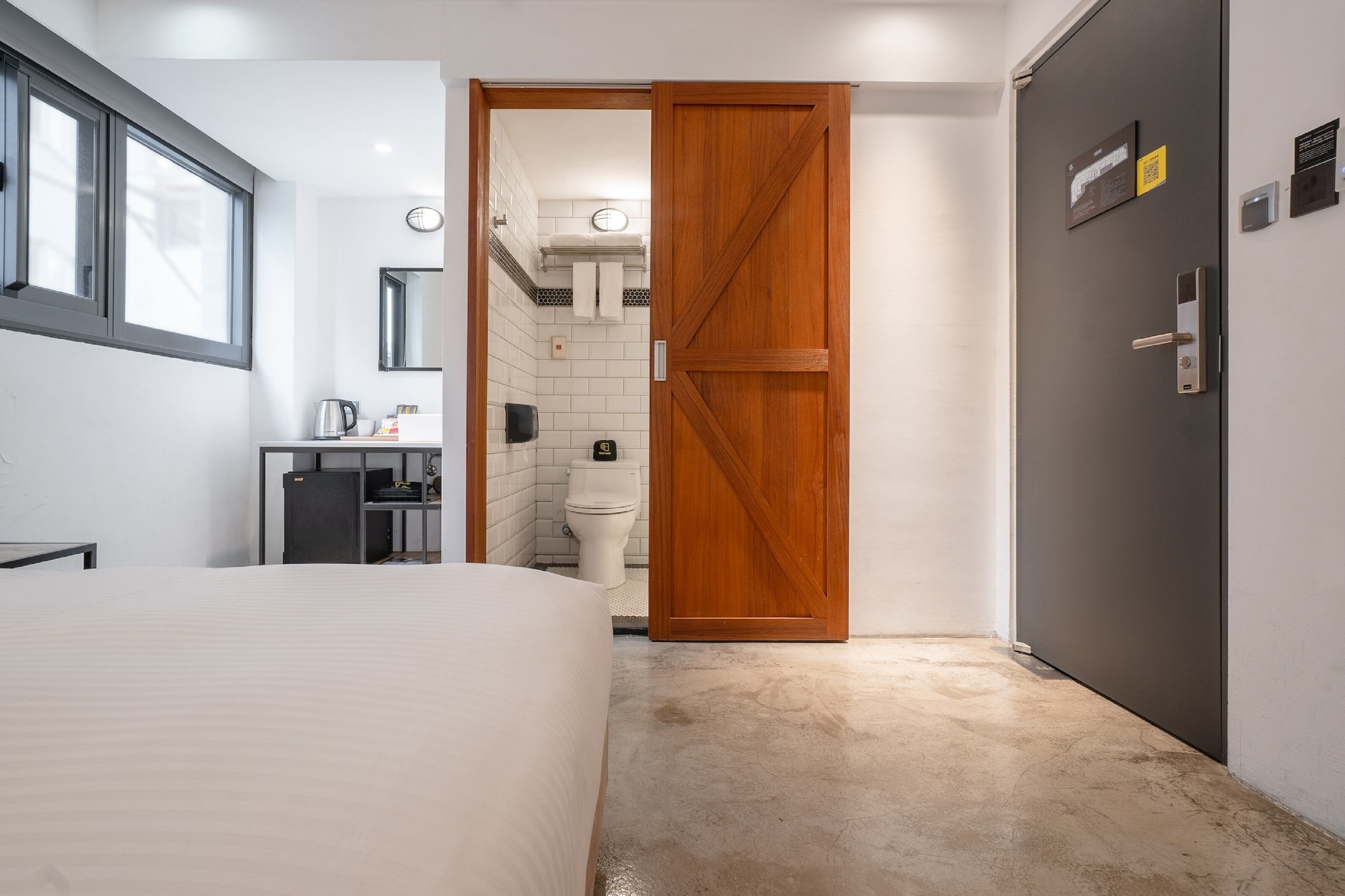 Een slaapkamer met een bed, een garderobe en een badkamer die door een open deur zichtbaar is.