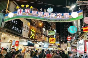 A busy street scene with a prominent sign for the Feng Chia Night Market. - Chase Walker Hotel (Taichung)