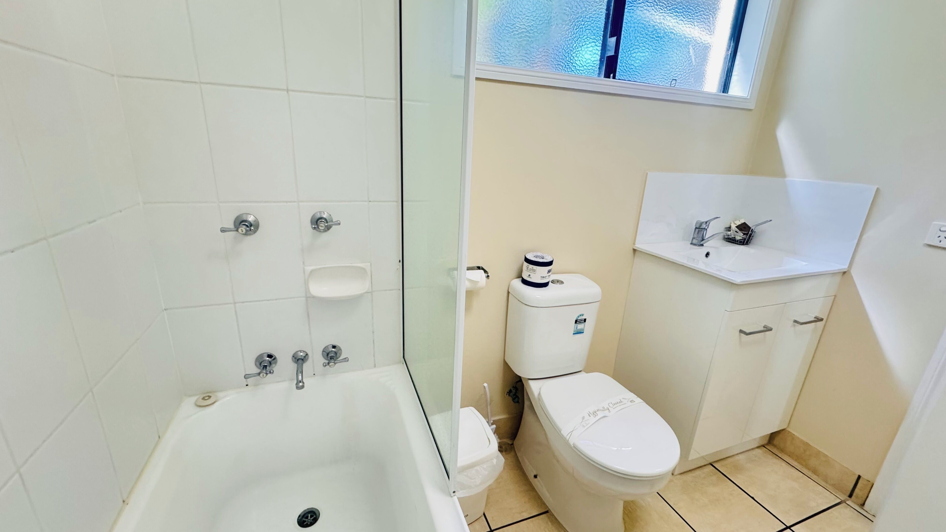 A bathroom with a bathtub, toilet, and sink.