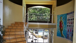 A multi-level interior with a staircase, a balcony, and a poster on the wall. - Amandari Cove (General Santos)