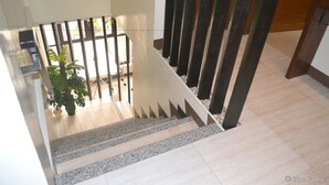 Eine Treppe mit Glasgeländer, die zu einem Außenbereich mit einem Blumentopf führt.