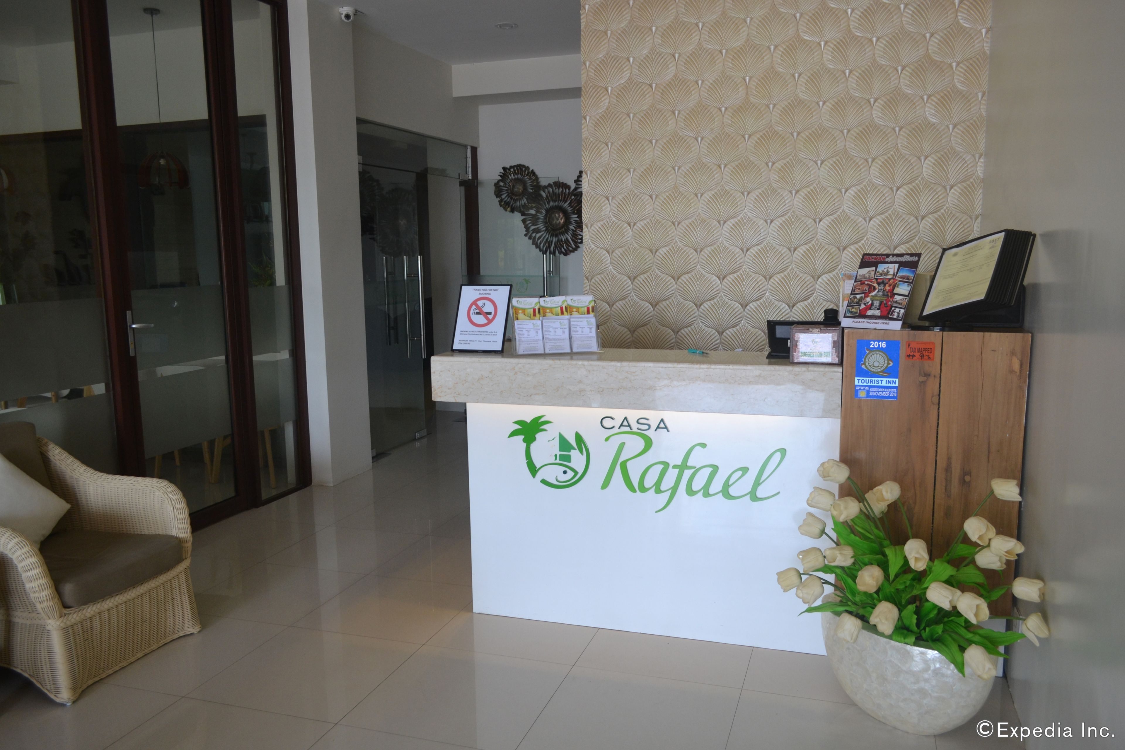 A reception desk with a sign reading "CASA Rafael" and a flower arrangement.