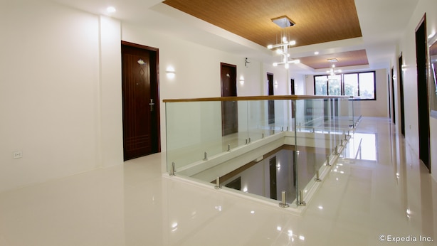 Un intérieur d’hôtel moderne avec une rambarde en verre, un plafond en bois et un sol propre et poli.
