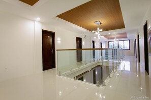 A modern hotel interior with a glass railing, wooden ceiling, and a clean, polished floor. - Casa Rafael Business Inn (General Santos)