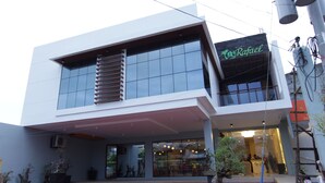 Un bâtiment moderne doté d’une façade en verre, d’une entrée bien visible et d’une enseigne portant le nom « Rafael ».