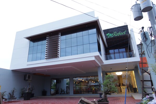 A modern building with a glass facade, a visible entrance, and a sign reading "Rafael".