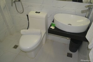 A bathroom with a toilet, sink, and shower.