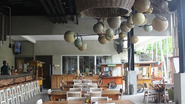 A spacious dining area with high ceilings and hanging wicker lamps. Tables and chairs are arranged for dining. - Greenotel Cilegon (Cilegon)