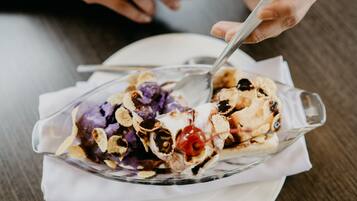 A dessert in a clear glass dish with a spoon, placed on a white napkin.