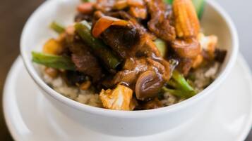 Un plato con comida variada, que incluye carne y verduras, servido sobre un plato blanco.