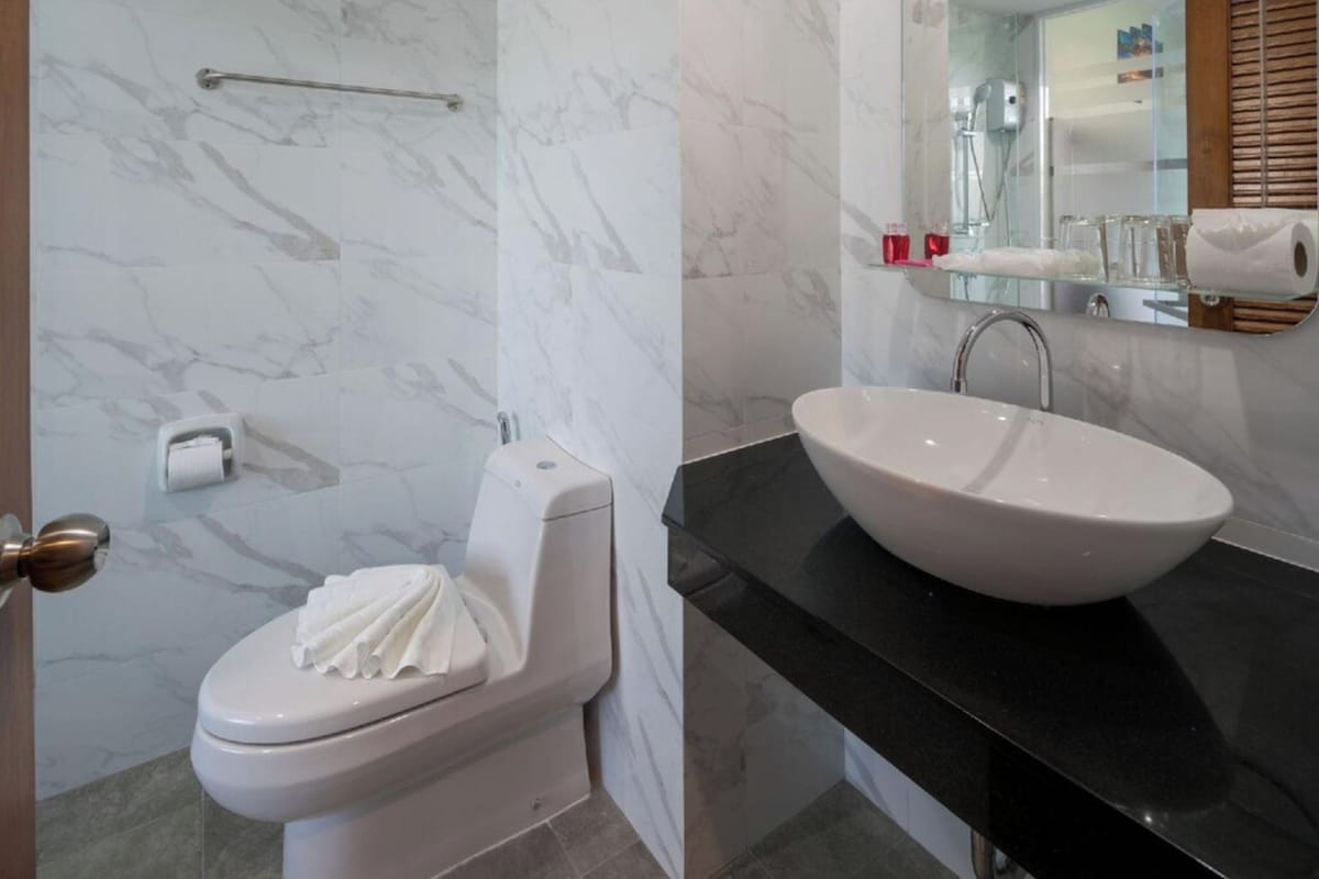 Une salle de bain avec des toilettes, un lavabo et un miroir.