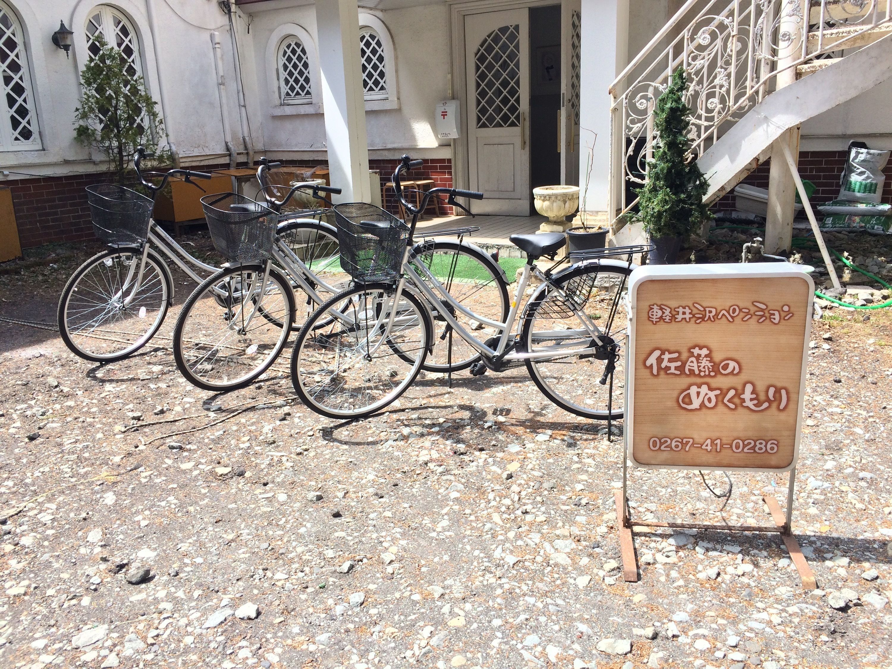 A bicycle parked in front of a building with a signboard.