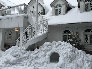 A snow-covered house with a white staircase leading to a balcony. - Karuizawa Pension Satou no Nukumori (Karuizawa)