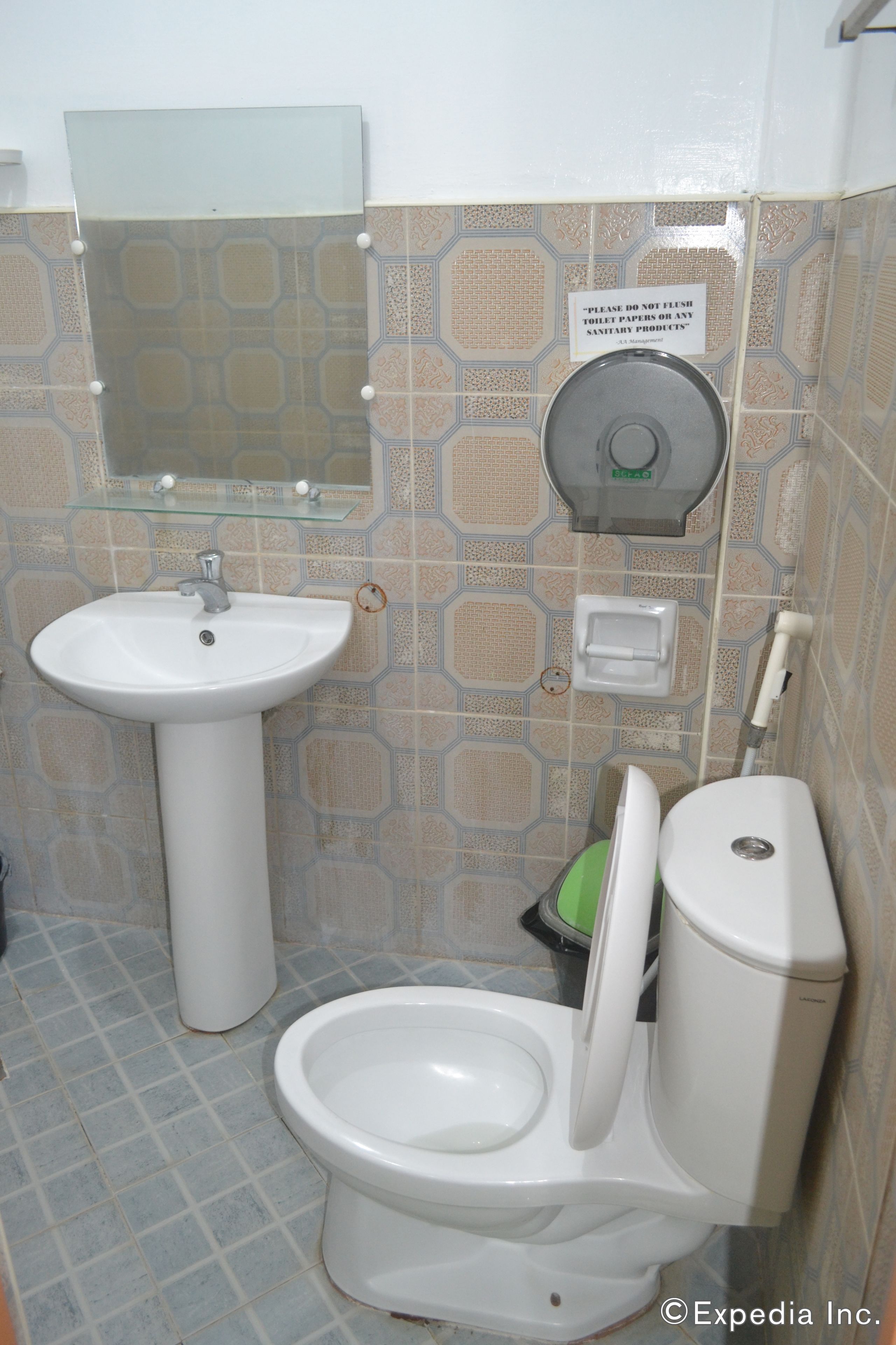 Une salle de bain équipée de toilettes, d’un lavabo et d’un sèche-mains.