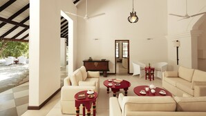 A spacious living area with a high ceiling, ceiling fans, and a view of the outdoors. - Jetwing Kaduruketha (Wellawaya)