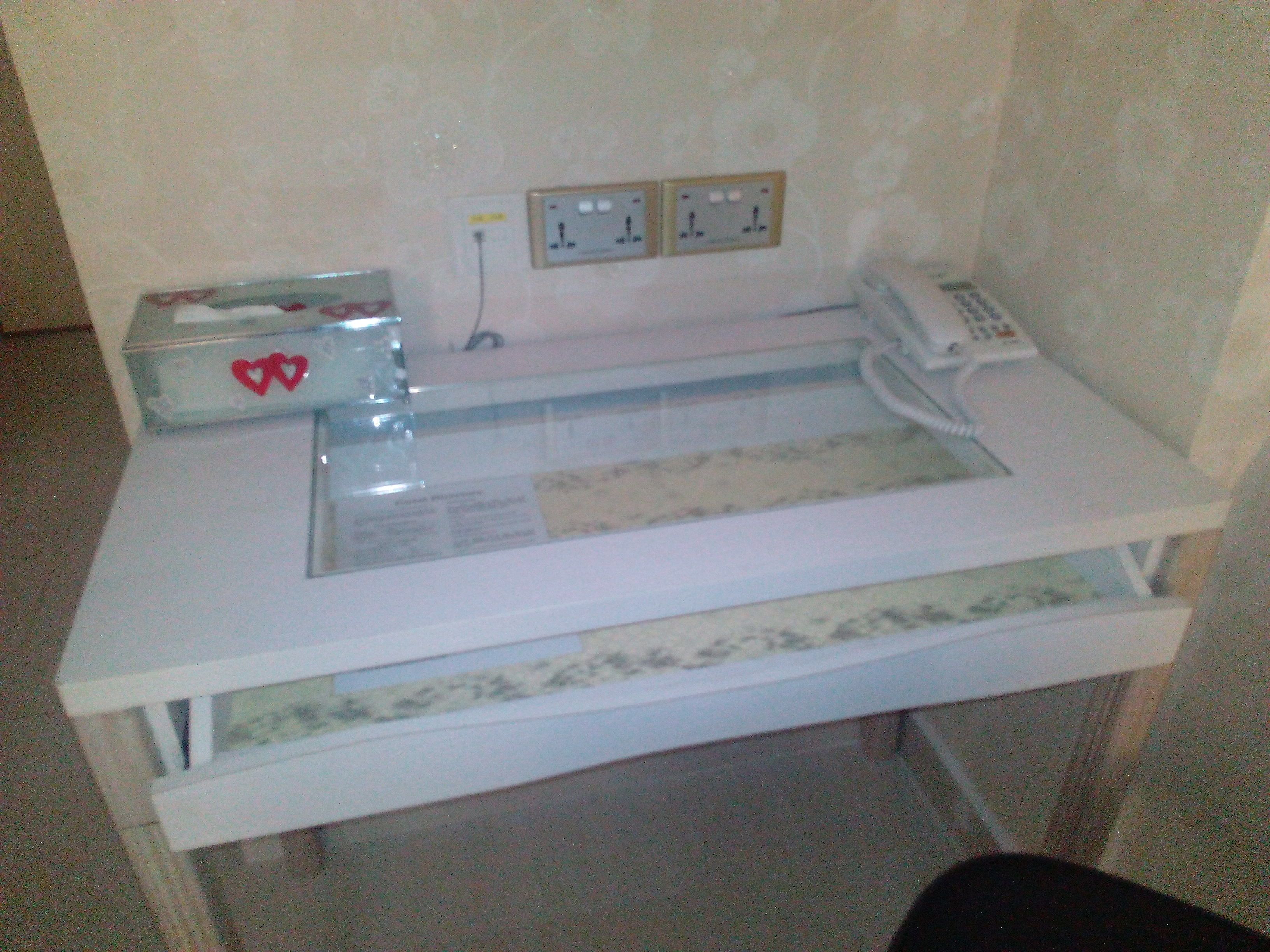 A small kitchen area with a countertop, a sink, and a telephone.