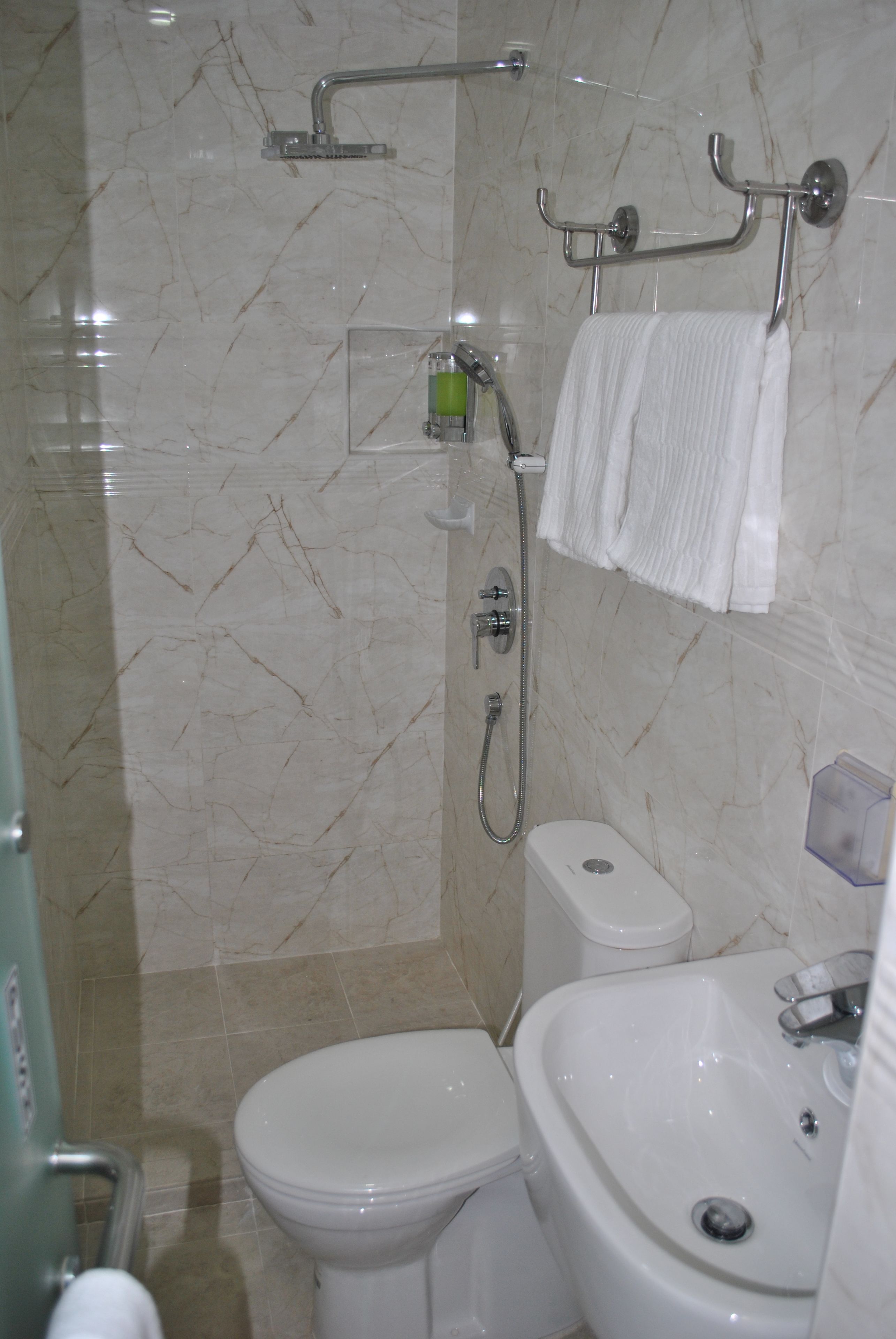 A bathroom with a toilet, sink, and shower.