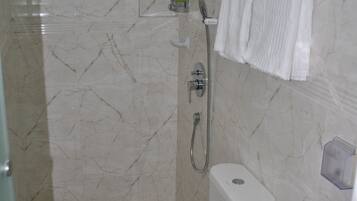 A bathroom with a toilet, sink, and shower.