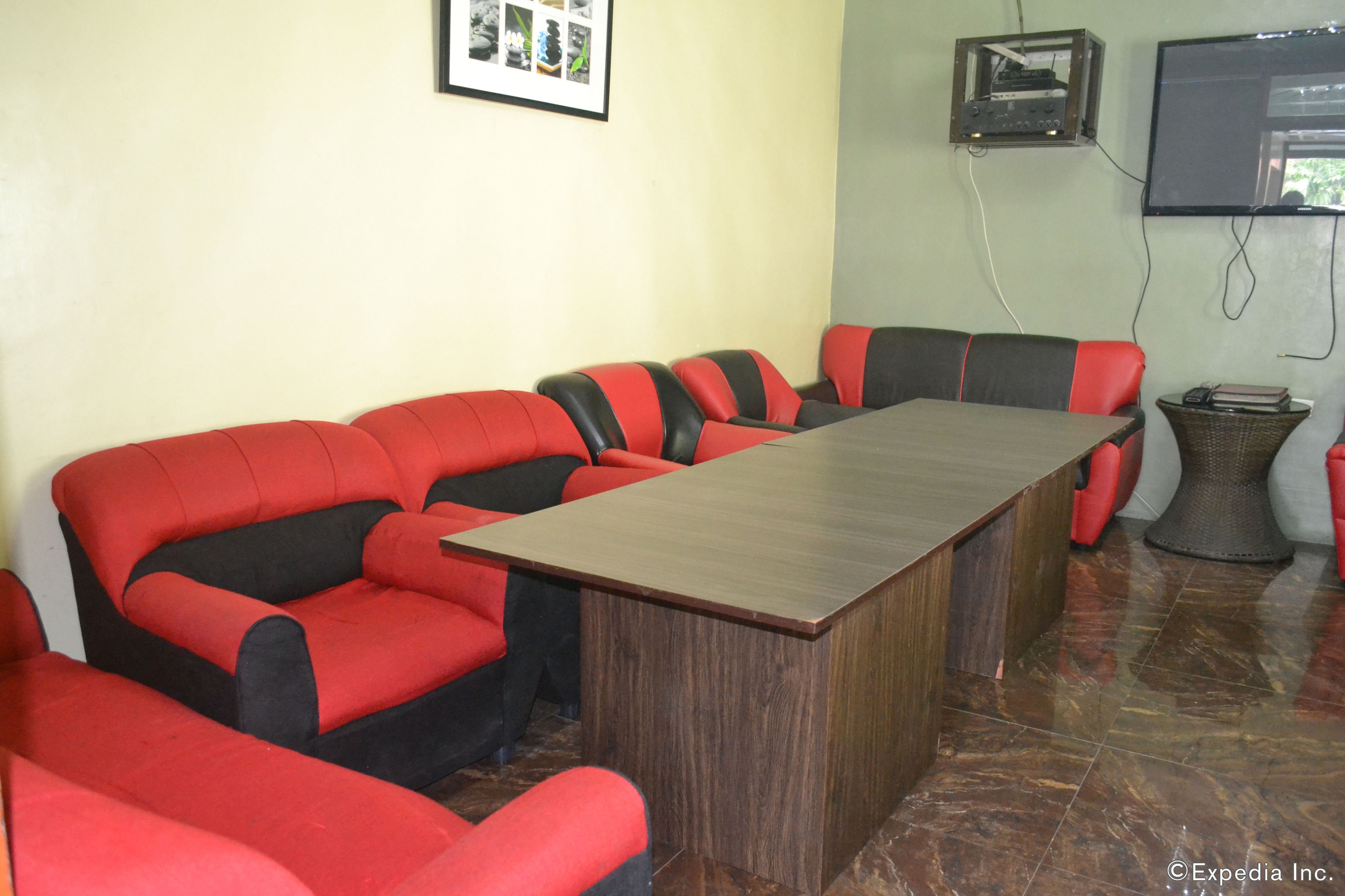 Un salón de conferencias con una mesa larga y sillas tapizadas en rojo y negro.