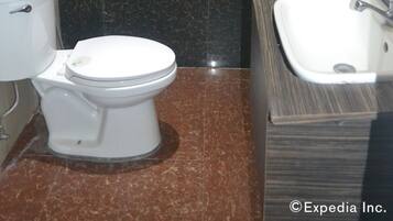 Un baño con inodoro, lavamanos, bañera y ducha.