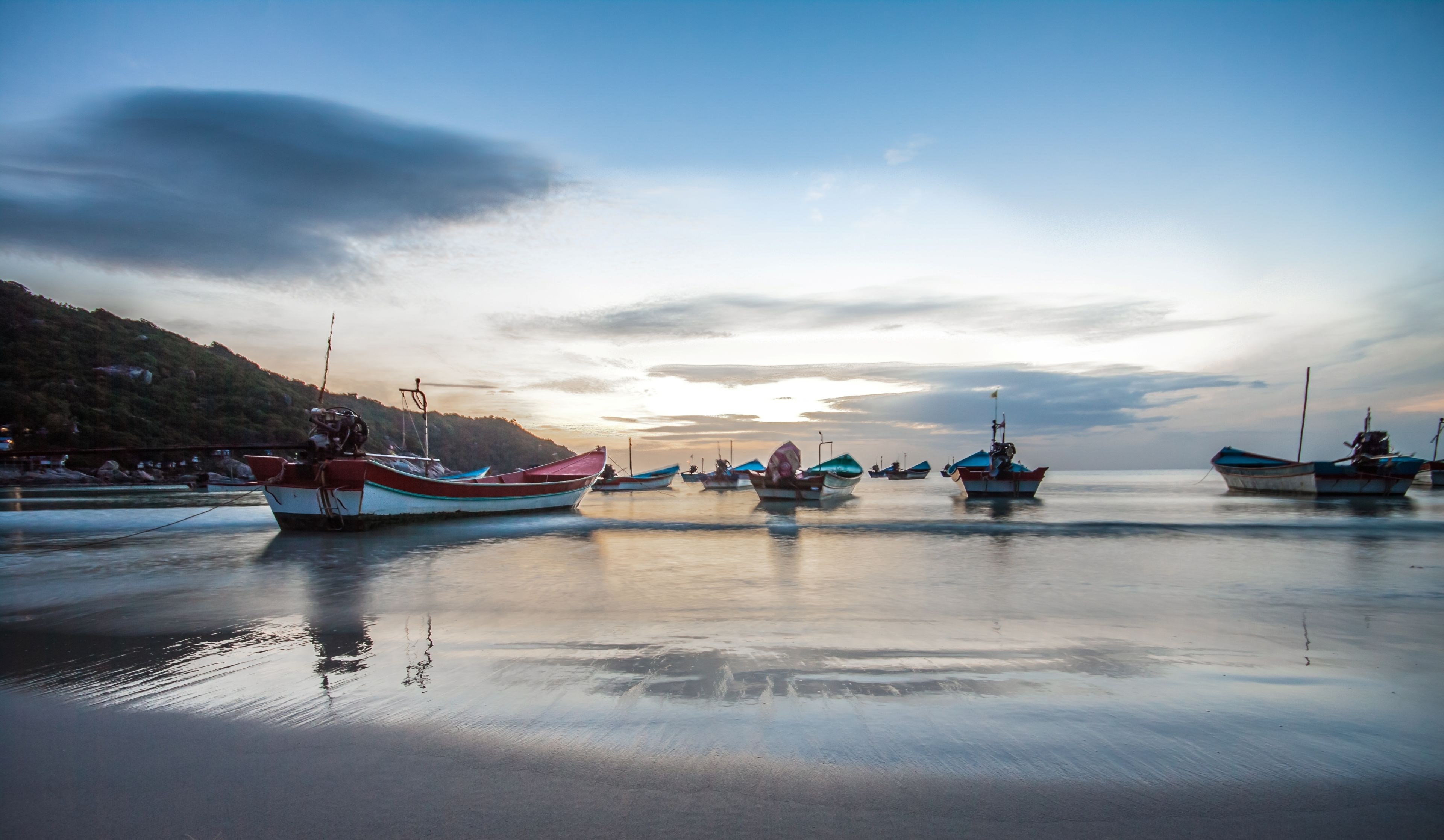 A calm harbor with several boats anchored.