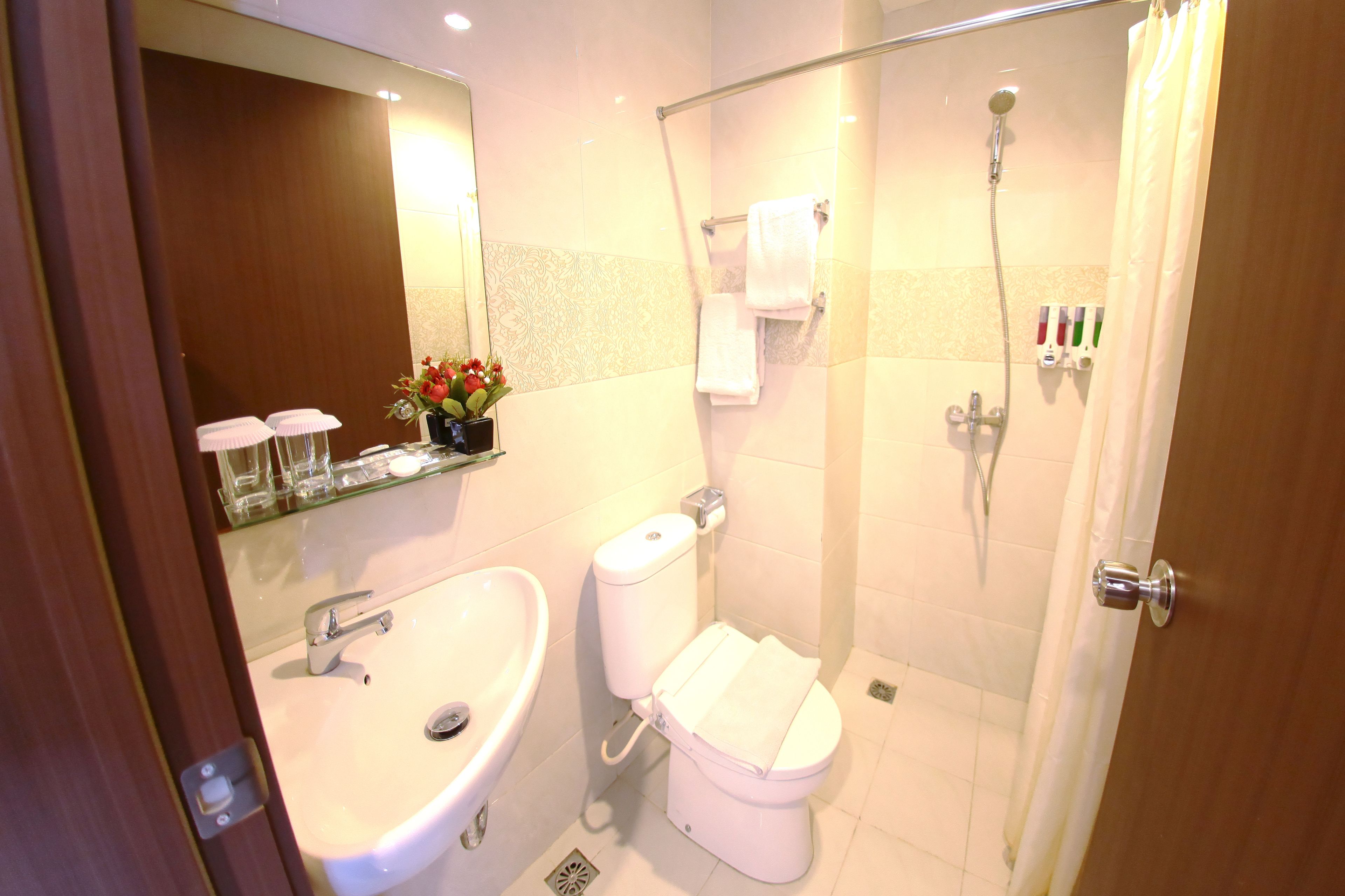 Un baño con lavamanos, inodoro y ducha.