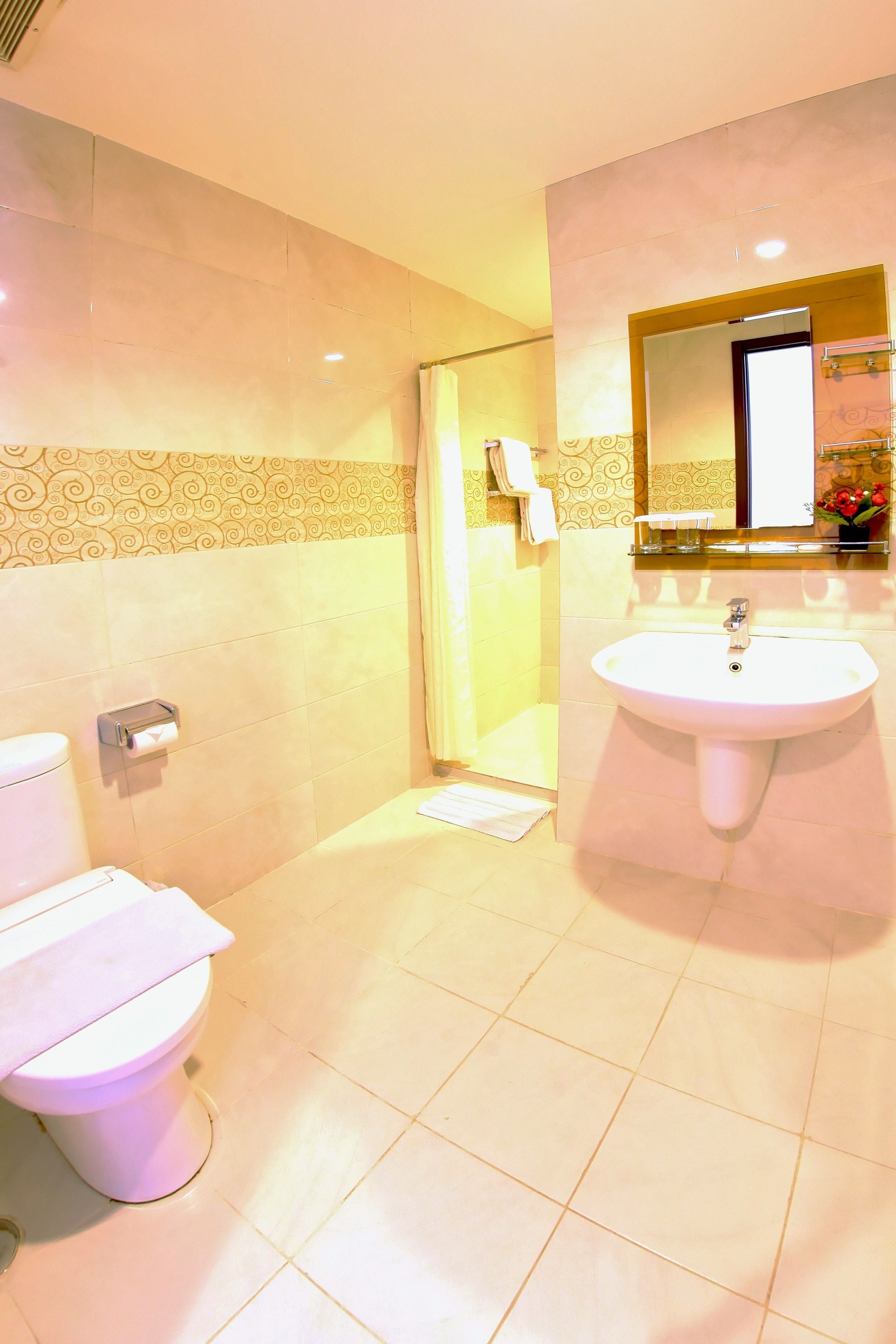 A bathroom with a toilet, sink, and shower.