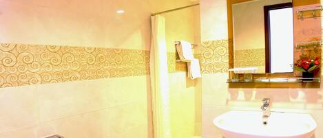 A bathroom with a toilet, sink, and shower.