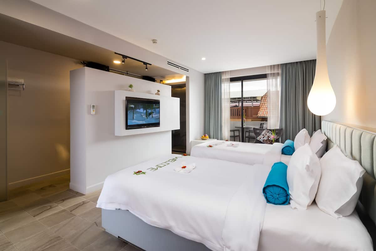 A hotel room with two beds, a TV on the wall, a balcony with a view, and a modern design.