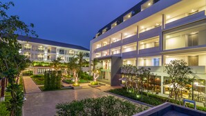A modern hotel with multiple floors, outdoor seating areas, and well-lit pathways. - Damrei Angkor Hotel (Siem Reap)