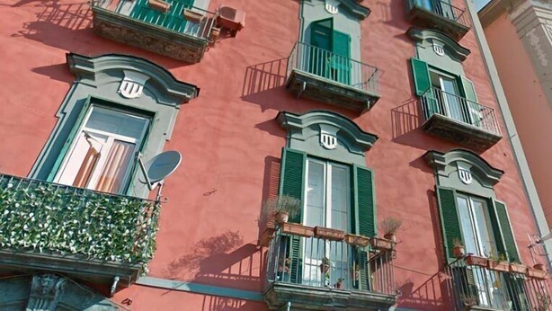 A multi-story building with balconies, green shutters, and satellite dishes. - B&B I Tetti Napoli (Naples)