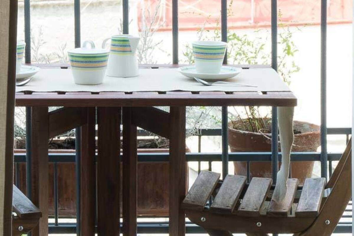 A wooden table with a white pitcher, two white cups, and a plate.