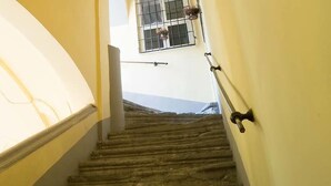 A staircase with a handrail, a window with bars, and a view of the outside. - B&B I Tetti Napoli (Naples)