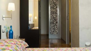 A hotel room with a bed, bedside table, lamp, and a decorative wall panel. - B&B I Tetti Napoli (Naples)